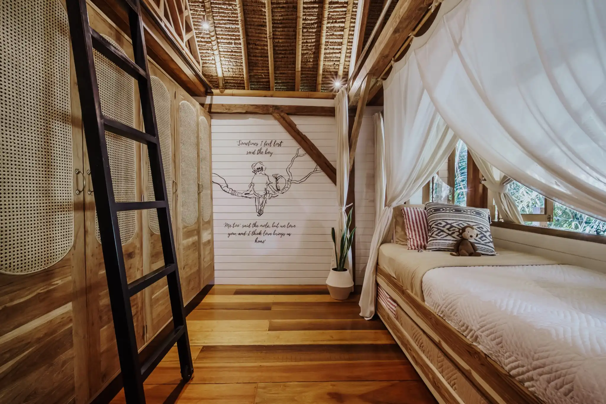 Children's bedroom with canopy bed and loft ladder